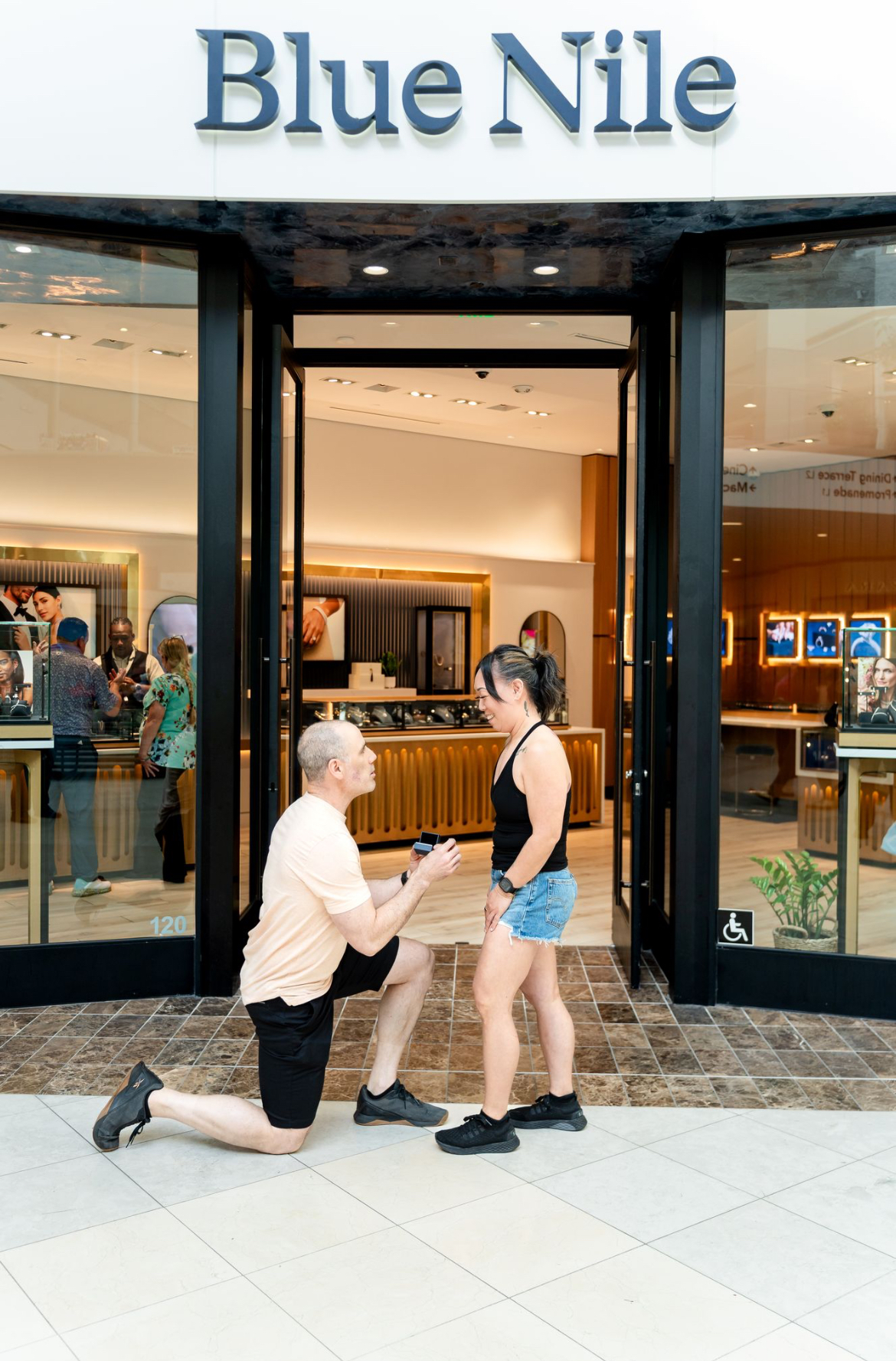 Couple at a marriage proposal outside the Blue Nile store during the grand opening event