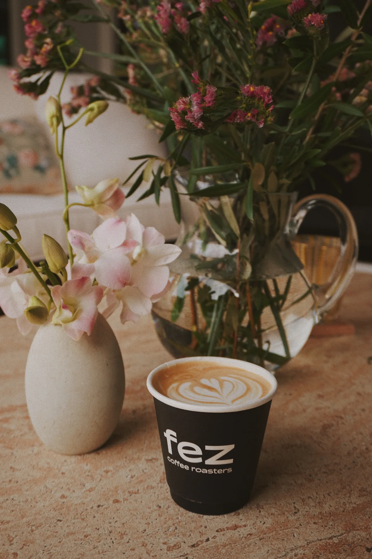 A barista standing behind a styled espresso cart at a corporate event, preparing drinks for guests