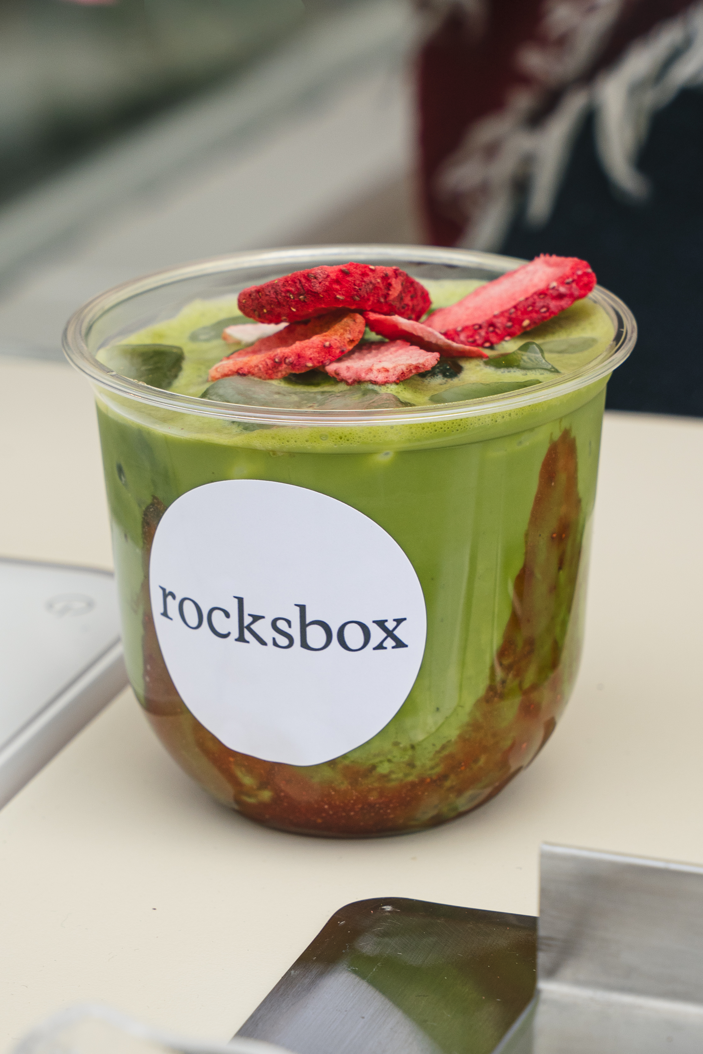 Rocksbox branded matcha cup with freeze-dried strawberry topping at a Fez Coffee brand activation.