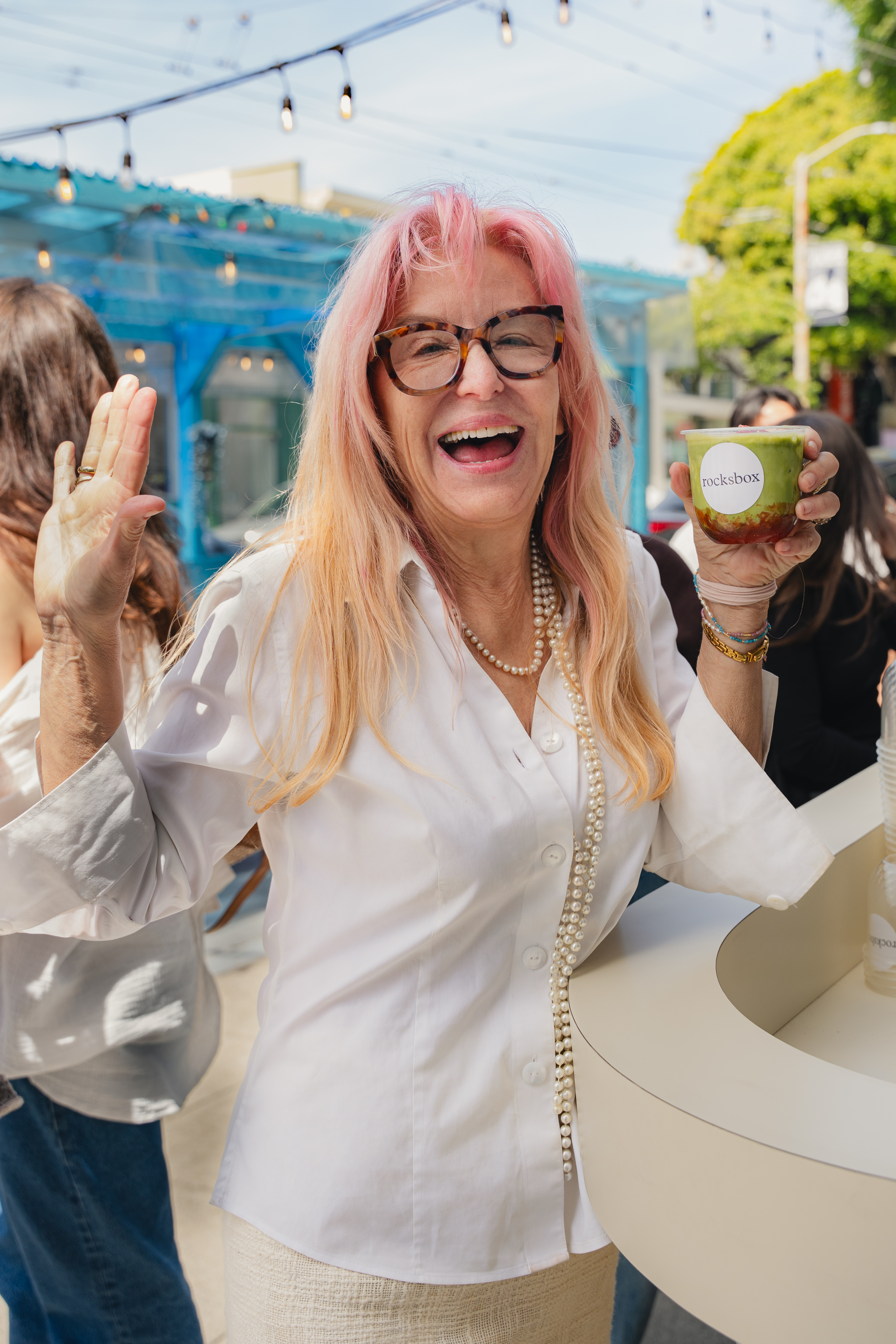 Guest laughing and holding a Rocksbox branded matcha cup at a Fez Coffee brand activation in San Francisco.